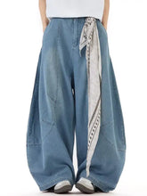 Men’s full size wash wide-leg jeans in medium-wash denim with a relaxed fit and a black and white geometric scarf at waist