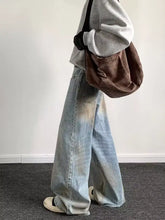 Brown suede shoulder bag with soft slouchy design paired with men’s plus size wide leg jeans feature full size fit