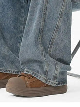 Men’s wide leg jeans paired with brown suede rubber platform sneakers featuring a classic lace up design