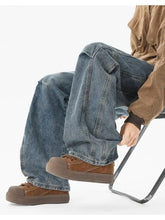Men’s brown suede lace-up platform shoes paired with wide leg jeans featuring a thick rubber sole