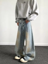 Men’s full size wash wide-leg jeans feature a faded light blue wash and subtle color gradient effect in denim