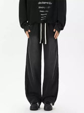 Men’s full size wash wide-leg jeans in black with white drawstrings and relaxed tapered fit shown with tape measure