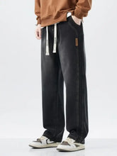 Men’s black washed loose fit denim wide leg jeans with white drawstrings and brown leather side patch plus size