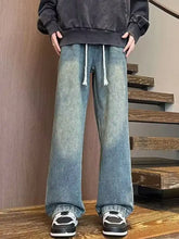 Men’s full size washed wide leg jeans in faded blue denim with white drawstrings at the waist