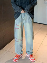 Men’s light-wash denim full size washed wide leg jeans with red stitched tear designs on the legs