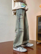 Men’s full size washed wide leg jeans in light green washed denim with dark stitching and distressed details