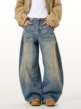 Men’s full size washed wide leg jeans in faded blue denim with distressing and raw hem edges
