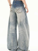 Men’s full size washed wide leg jeans in faded blue denim with distressed details and embroidered x logo on back pocket view