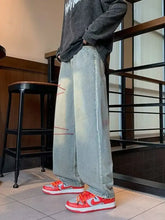 Men’s full size washed wide leg jeans in light-wash denim with faded distressing and red stitching details