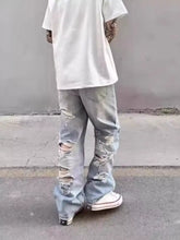 Men’s full size washed wide leg jeans in light-wash denim with distressed ripped knees and frayed hems