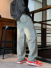 Men’s full size washed wide leg jeans in light-wash denim with faded distressing and red stitching details