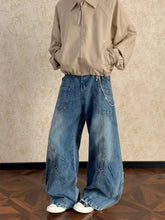 Men’s full size washed wide leg jeans in medium-wash blue denim with visible stitching and patchwork details