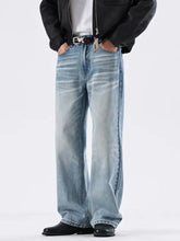 Men’s light-wash denim jeans with a relaxed fit and washed wide leg cut featuring subtle fading for a modern look