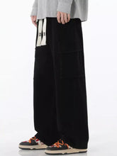 Men’s full size wide leg cargo jeans in black with a soft velvety texture and large side pockets