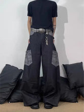 Men’s full size wide-leg cargo jeans in black denim with gray geometric patchwork on thighs featuring wide-leg cargo style