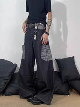 Men’s full size wide-leg cargo jeans in black with gray geometric patchwork pockets and a studded belt detail