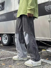 Men’s full size wide leg distressed jeans in dark gray denim with light gray patchwork panels and frayed edges