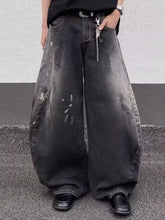 Men’s full size wide leg distressed black denim jeans with faded worn look and subtle white paint splatter details