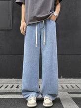 Men’s full size light-wash denim wide leg jeans with white drawstrings and subtle x branding front view
