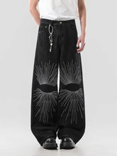 Men’s full size wide leg jeans in black denim featuring bold eye-shaped designs with silver rhinestones on leg jeans