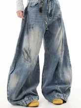 Men’s full size wide leg jeans in faded blue denim with subtle yellow distressing and visible stitching details