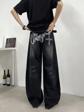 Back side of men’s full size black denim wide leg jeans with bold white courage graphic and cross design on pockets