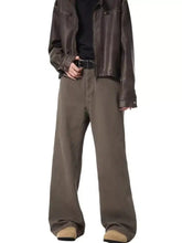 Men’s full size wide leg jeans paired with a brown faux leather jacket with matte finish and subtle stitching details