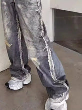 Men’s full size wide leg dark-wash denim jeans with distressed frayed edges and intentional wear patterns