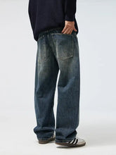 Men’s full size wide leg dark-wash denim jeans with relaxed fit and visible stitching on back pockets shown from the back side