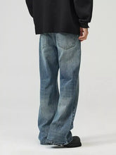 Men’s full size wide leg jeans in faded blue denim with subtle distressing and classic back pockets for perfect fit