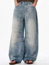 Men’s full size wide leg jeans in faded light blue denim with distressing and seam detailing