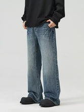 Men’s full size wide leg jeans in faded medium blue denim with subtle distressing and frayed hems for a perfect fit