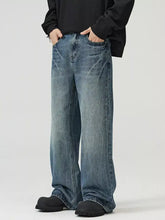 Men’s full size wide leg jeans in faded medium-blue denim with subtle whiskering and frayed hems for a perfect fit
