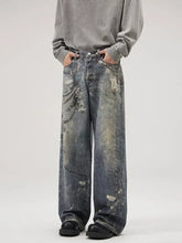 Men’s full size wide leg washed denim jeans in faded blue with distressed paint splatter and size wide leg cut