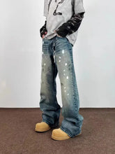 Men’s distressed blue denim flare jeans with unique white paint splatter accents in plus size wide leg fit