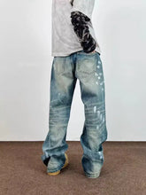 Men’s full size wide leg blue denim jeans with unique white paint splatter detail and distressed finish