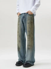 Men’s full size wide leg relaxed fit jeans in faded blue denim with distressed olive green stain patterns
