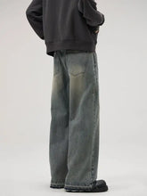 Men’s full size wide leg relaxed fit jeans in faded gray denim with frayed hems and subtle distressing