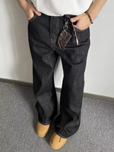 Men’s full size wide leg dark-wash denim jeans with visible stitching details made from a premium cotton blend