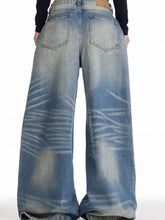 Back view of men’s full size wide leg wash jeans in faded blue denim with classic pockets and brown leather patch