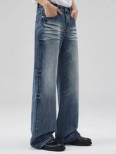Men’s full size wide-leg wash jeans in medium-wash blue denim with relaxed fit and subtle distressed details