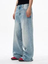 Men’s full size wide leg washed light-wash denim jeans with faded distressed look and vertical seam detailing