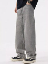 Men’s loose fit wash jeans in gray denim with wide leg, relaxed fit, slight fade, and visible stitching details