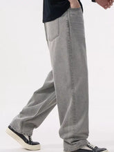 Men’s loose fit wash jeans in light gray denim with wide legs, relaxed fit, and frayed hems