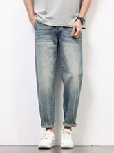 Men’s loose fit washed light-wash denim jeans with a relaxed tapered fit and rolled cuffs