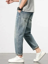 Men’s loose fit washed light-wash denim jeans with relaxed tapered fit and rolled cuffs for casual wear