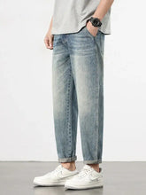 Men’s loose fit washed light-wash denim jeans with a relaxed tapered fit and rolled cuffs for casual wear