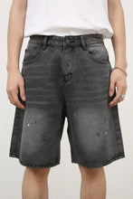 Mens mid rise denim shorts in basic style with distressed black fabric and paint splatters