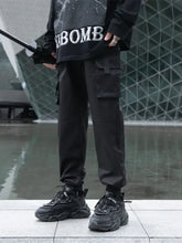 Man in mens plus size cargo jogger pants with pockets, black shirt and sneakers