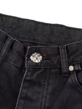 Men’s plus size cross loose fit black denim jeans with a silver-toned flower-inspired embossed button